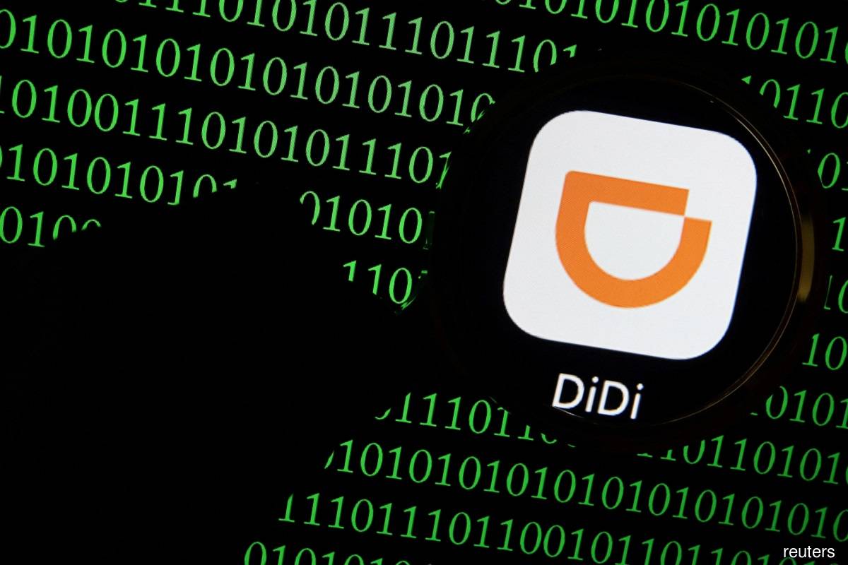 The app logo of Chinese ride-hailing giant Didi is seen through a magnifying glass on a computer screen showing binary digits in this illustration picture taken July 7, 2021. (Reuters pic) 